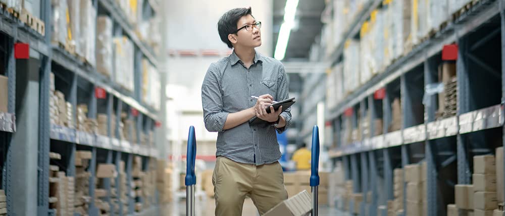 一位在仓库中使用平板电脑的男子